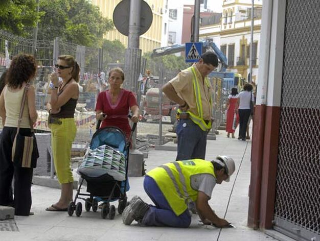 Todos en un mismo lugar. Obreros trabajan en el pavimento mientras los peatones pasan junto a ellos o se entretienen charlando.

Foto: Manuel G&oacute;mez