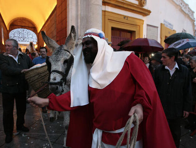 Un page del Heraldo Real sale por una de las puertas de la Maestranza seguido de un burro.

Foto: Juan Carlos Mu&ntilde;oz