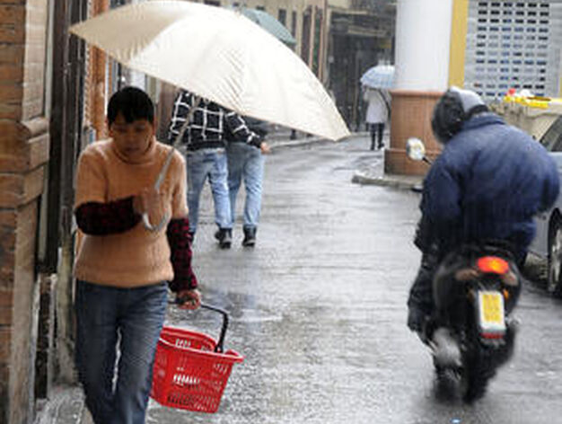 Una mujer se dirige a hacer la compra a pesar de las precipitaciones.

Foto: J. C. V&aacute;zquez, B. Vargas y A. Pizarro