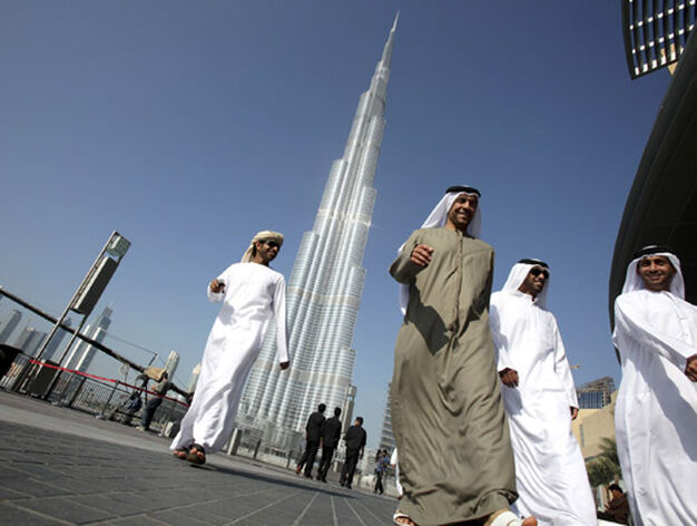 Un grupo de dubait&iacute;es pasea bajo la Burj Dubai. / Reuters