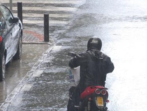 Un motorista circula con precauci&oacute;n protegido de la lluvia con un impermeable.

Foto: J. C. V&aacute;zquez, B. Vargas y A. Pizarro