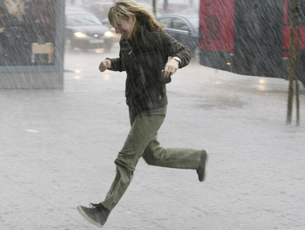 Una mujer corre en busca de un lugar para protegerse de la lluvia.

Foto: J. C. V&aacute;zquez, B. Vargas y A. Pizarro
