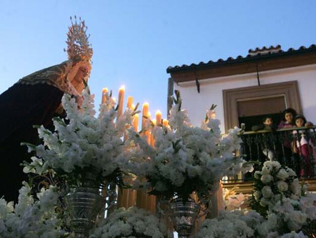 Tras personas observan desde un balc&oacute;n el avance de la Virgen del Mayor Dolor de Los Barrios

Foto: J. M. Q./Shus Teran