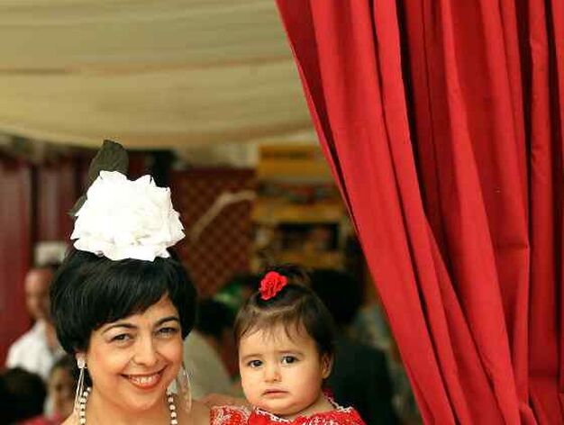 Inma y su hija Mar&iacute;a contemplan la belleza de la Feria asomadas entre las cortinas de caseta

Foto: M.A. Gonz&aacute;lez- Pascual