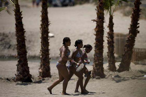Michelle Obama y su hija Sasha descansan en una playa de Estepona. / AFP