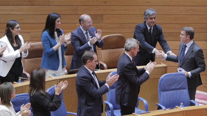 Alberto Núñez Feijóo, a la derecha, recibe la felicitación de diputados del Parlamento gallego ayer durante su investidura.