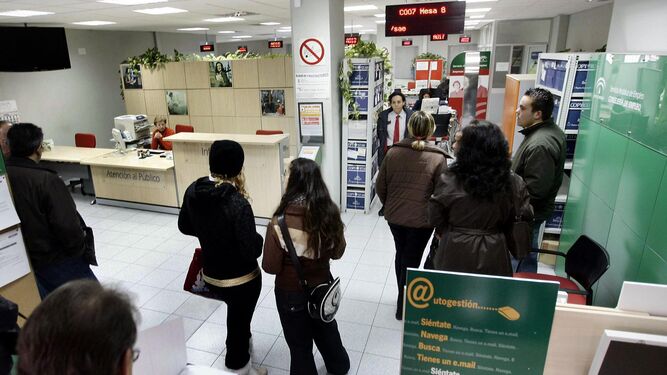 Varias personas esperan a ser atendidas en una oficina del Servicio Andaluz de Empleo (SAE).