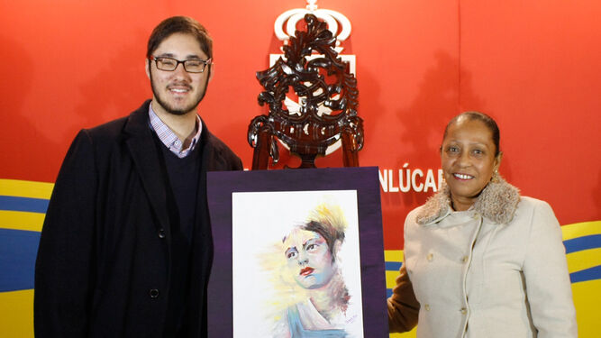 La concejala de Igualdad, Teresa Rúa, muestra el cartel anunciador junto a Gonzalo Neva, autor de la pintura.