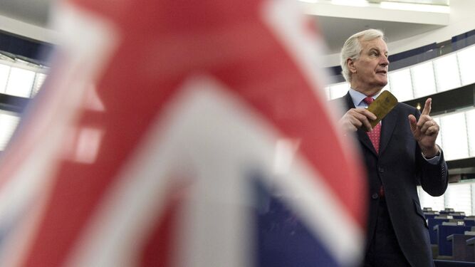 El negociador jefe de la UE, Michel Barnier, interviene en el pleno tras una bandera británica.
