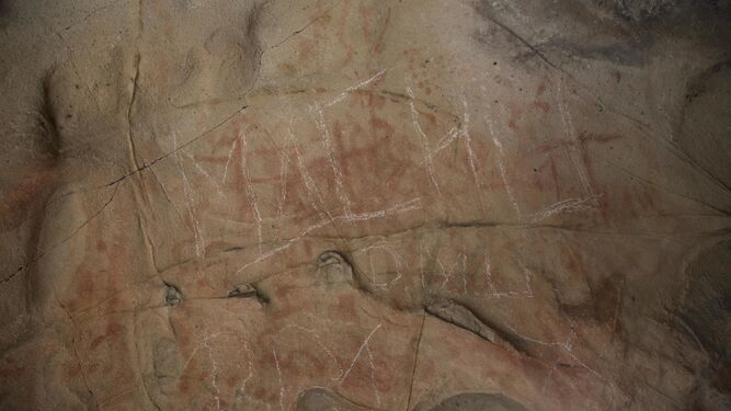 El panel principal, donde se observa los trazos blancos realizados aparentemente con una piedra arenisca sobre las pinturas rupestres.