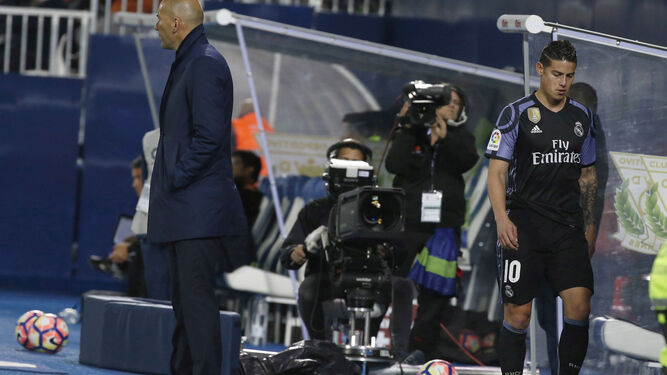 El colombiano James Rodríguez, con gesto serio tras ser sustituido en Leganés por Zinedine Zidane, que sigue el desarrollo del partido.