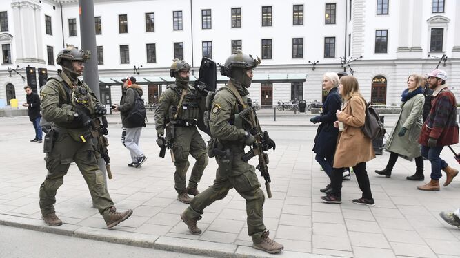 Miembros de las fuerzas especiales se dirigen a la estación central de Estocolmo mientras se cruzan con viandantes tras el atentado.