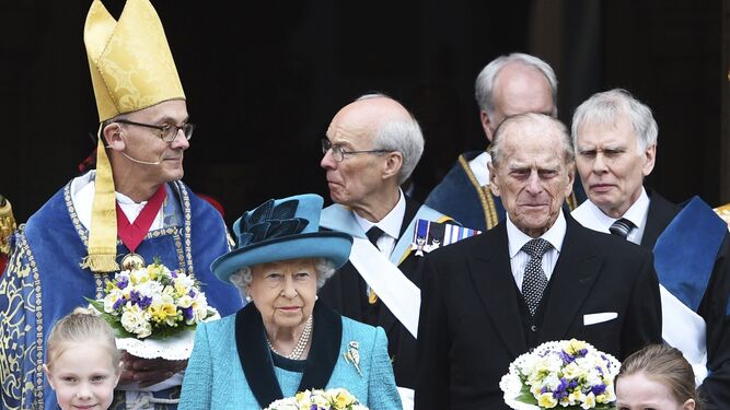 La reina Isabel (centro) y el duque de Edimburgo, a la salida del oficio.