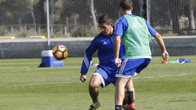 Garrido trata de alcanzar el balón en pugna con Santamaría durante una sesión en El Rosal.