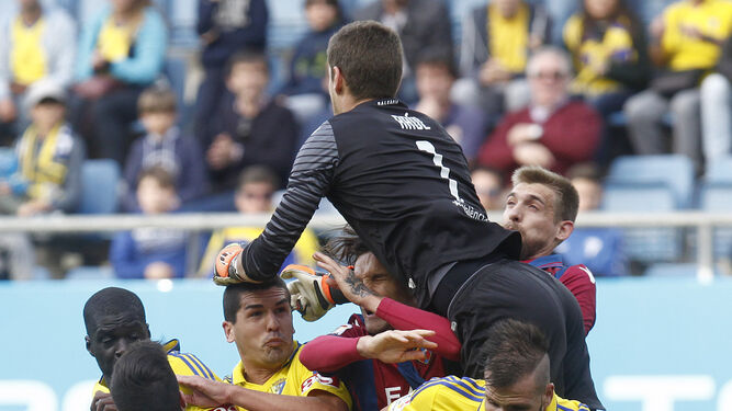 El portero del Levante sale a despejar de puños por encima de varios jugadores, entre ellos Ortuño y Garrido.