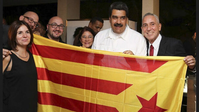 Maduro posa con una 'estelada' que sujetan varios independentistas en Caracas.