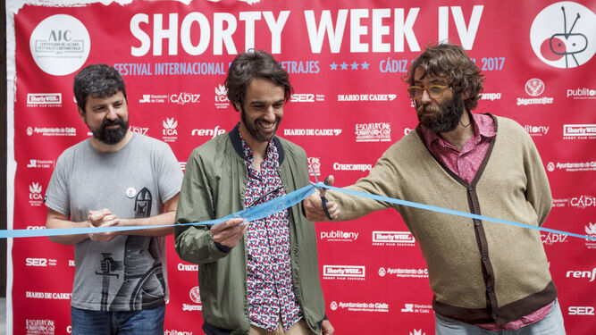 El coordinador de Shorty Week, Mikel Gil, mientras César y Jesús Guisado, de Monkey Week, cortan la cinta inaugural del festival de cortos.