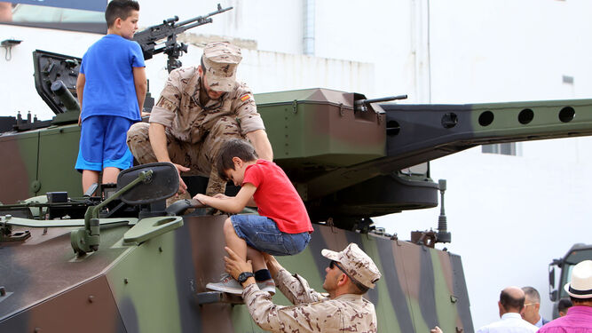 Dos pequeños suben a uno de los vehículos militares que ayer pudieron visitarse en la ciudad.