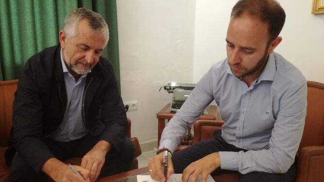 El alcalde y el presidente de la empresa pública firman el acuerdo.