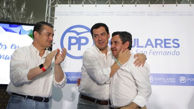Juanma Moreno abraza a José Loaiza junto a Antonio Sanz, ayer, en la clausura del congreso local del PP.