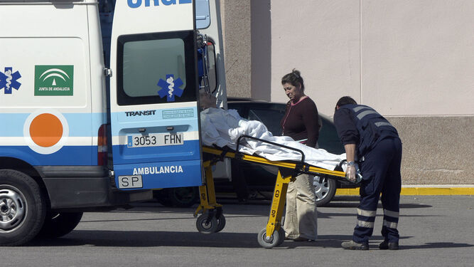 Un enfermo es trasladado en una camilla por los servicios de urgencias, a las puertas de un hospital.