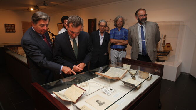 García León muestra algunas piezas de la exposición al rector de la UCA tras la inauguración.