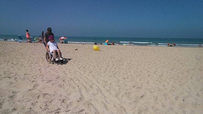 Una persona en silla de ruedas intenta acceder a la playa.