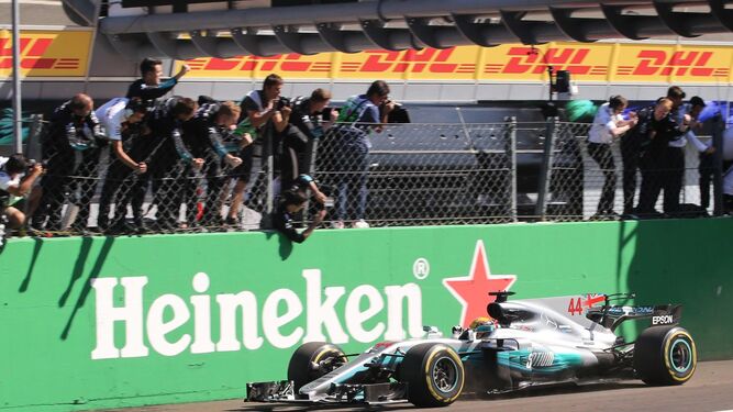 Los mecánicos de Mercedes se suben al muro para dar la enhorabuena a Lewis Hamilton.