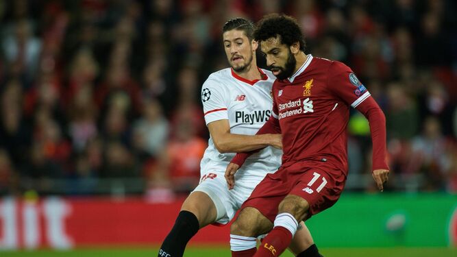 El sevillista Escudero intenta frenar al egipcio del Liverpool Salah.