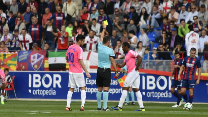 El árbitro muestra cartulina amarilla a Abdullah en Huesca en presencia de Rubén Cruz.