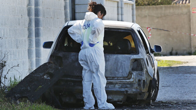 Una agente de la Policía Nacional, junto al coche en cuyo interior apareció el cadáver de Ángel Federico Rodríguez.