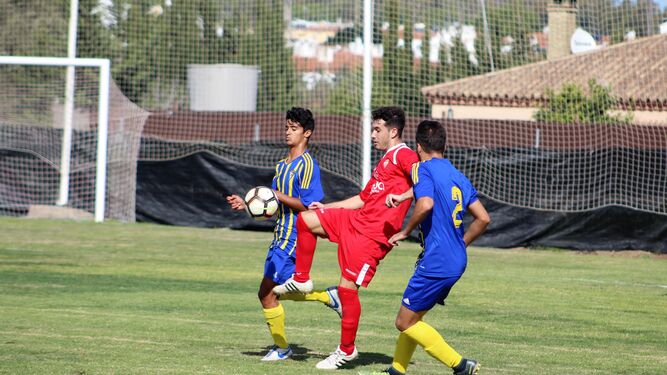 Javi Romero controla el esférico ante dos rivales en el partido contra el Balón de Cádiz.
