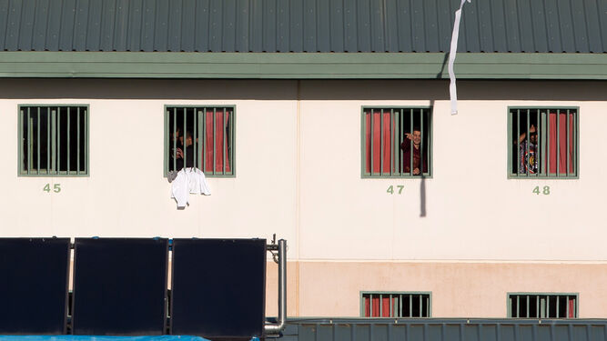 Un grupo de inmigrantes se asoma a las ventanas de la prisión de Archidona.
