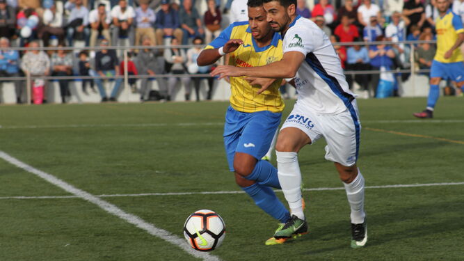 Brahim pugna con un jugador del Xerez DFC en el choque de ayer en el Pérez Ureba.
