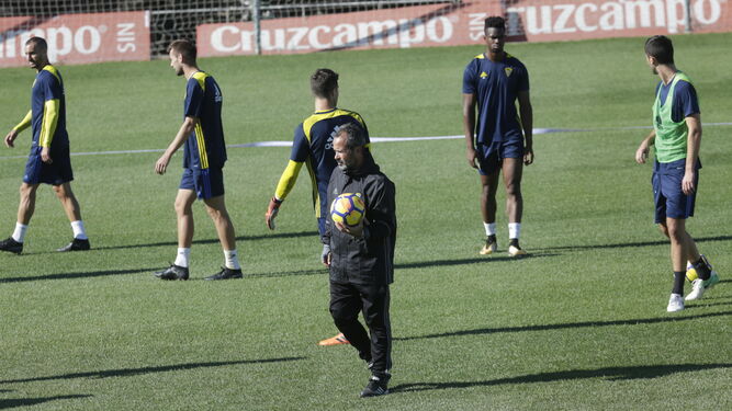Álvaro Cervera sostiene un esférico mientras sus jugadores se preparan para el inicio de un partido de entrenamiento en El Rosal.