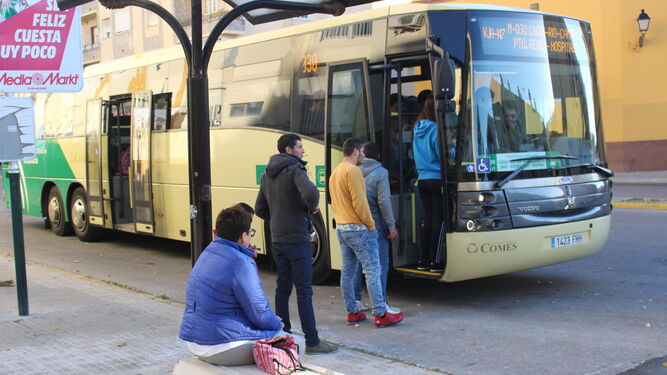 Un grupo de viajeros sube al autobús en la parada de las 512 viviendas.