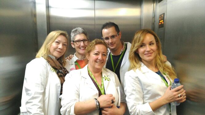 Voluntarios hospitalarios de la AECC en un ascensor del Hospital Puerta del Mar.