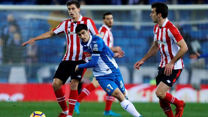 El delantero del Espanyol Gerard Moreno pelea el balón con los jugadores del Athletic Iturraspe y Lekue.