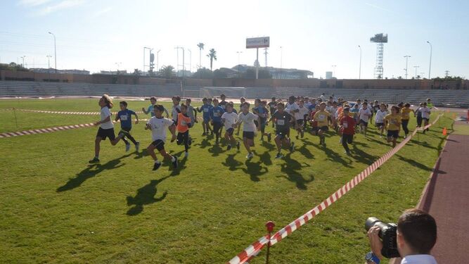 Niños corriendo en el Estadio Iberoamericano la prueba de Campo a Través.