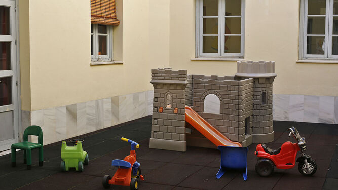Un castillo y varios juguetes, en el patio interior de la guardería municipal de la calle San Juan de Dios.