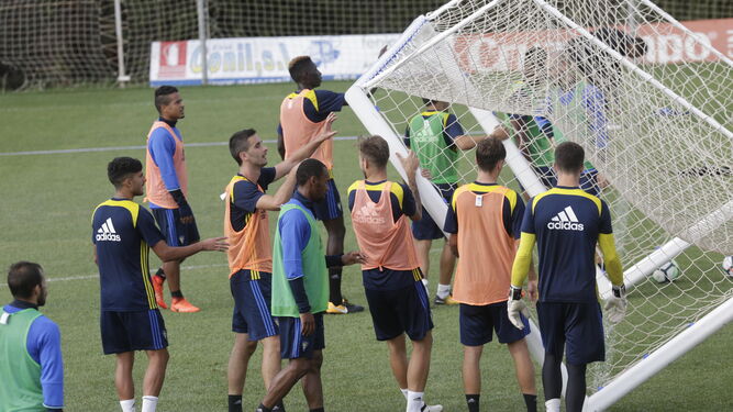 Los jugadores del Cádiz vuelcan una portería portátil en un entrenamiento.