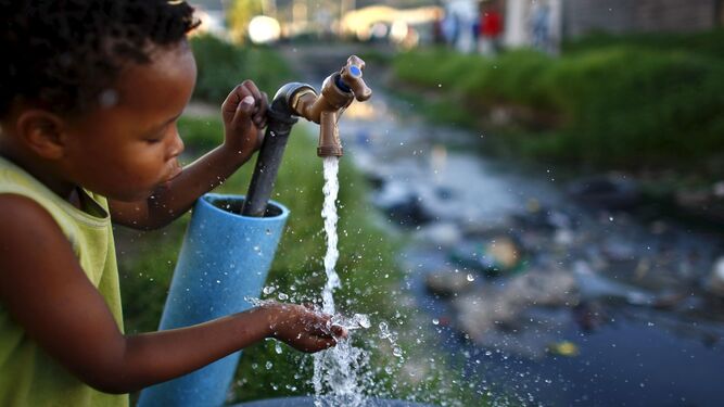Un niño sudafricano bebe agua de una fuente, en una imagen de archivo.