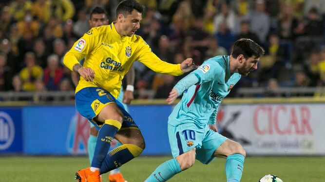 Leo Messi trata de zafarse de la marca de Ximo Navarro.
