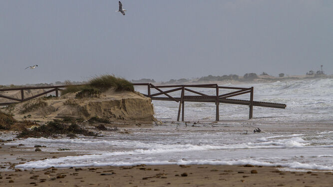 Una de las pasarelas de acceso de la playa, tras el temporal. Es visible en la imagen la ingente pérdida de arena.