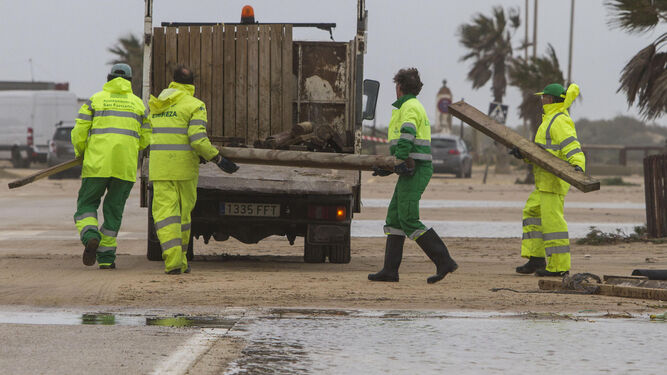 Operarios de limpieza, ayer, trabajando en los accesos de la playa.