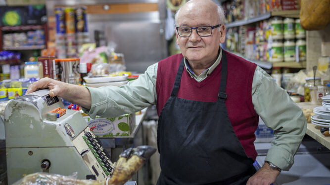Juan Garrido en su tienda con la mano derecha sobre su máquina registradora de toda la vida.
