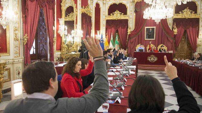 Los diputados levantan la mano para votar uno de los puntos del día.