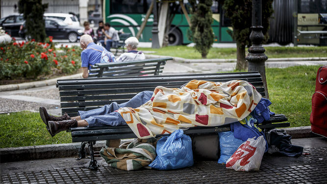 Una persona sin hogar descansa en un banco situado en la plaza de las Tortugas, en el centro de la ciudad.