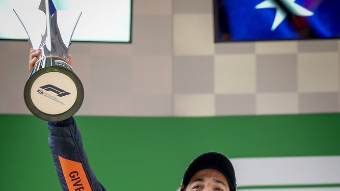 El piloto australiano Daniel Ricciardo levanta el trofeo del gran premio chino.
