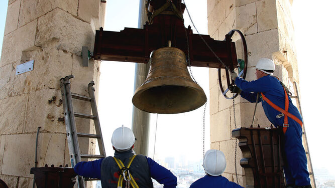 Los operarios colocan una de las cinco campanas que fueron izadas ayer a la Torre de Poniente.
